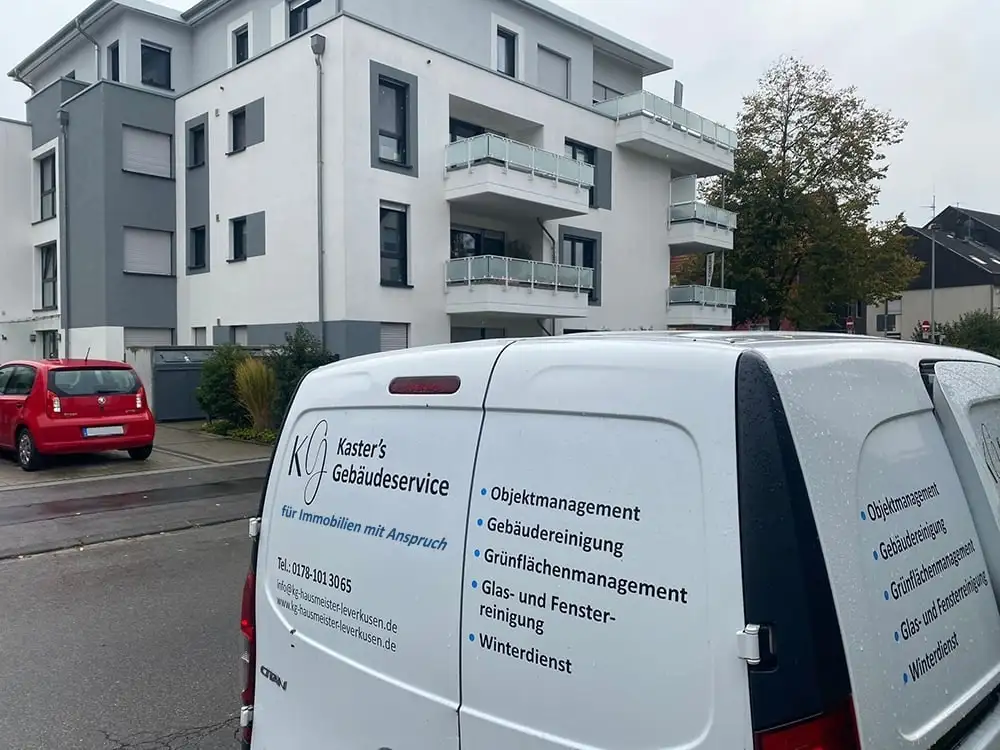 Fahrzeug von Kaster’s Gebäudeservice vor einem Mehrfamilienhaus