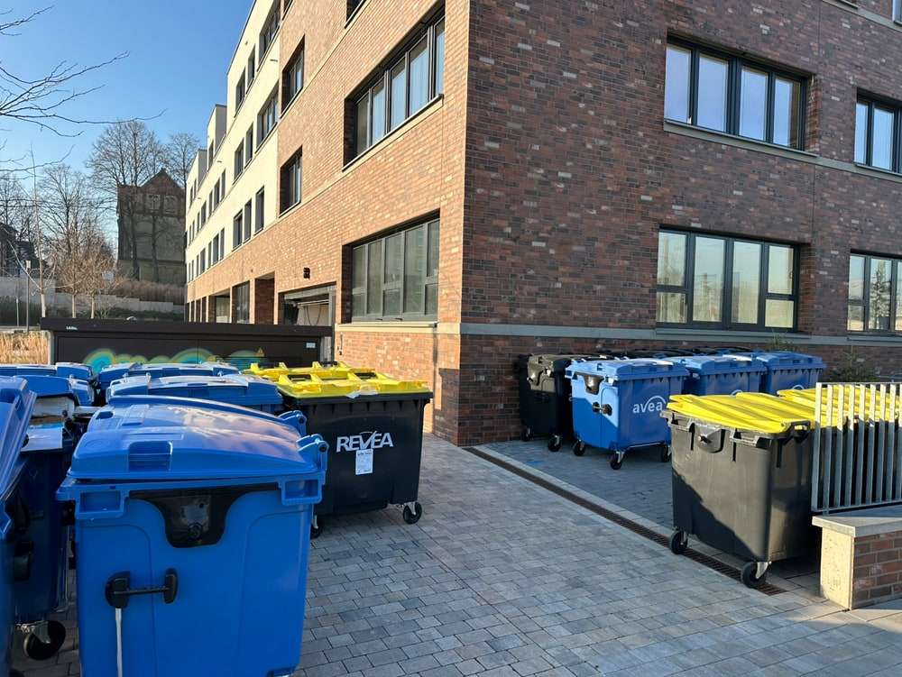 Bereitgestellte Mülltonnen vor einer Wohnanlage