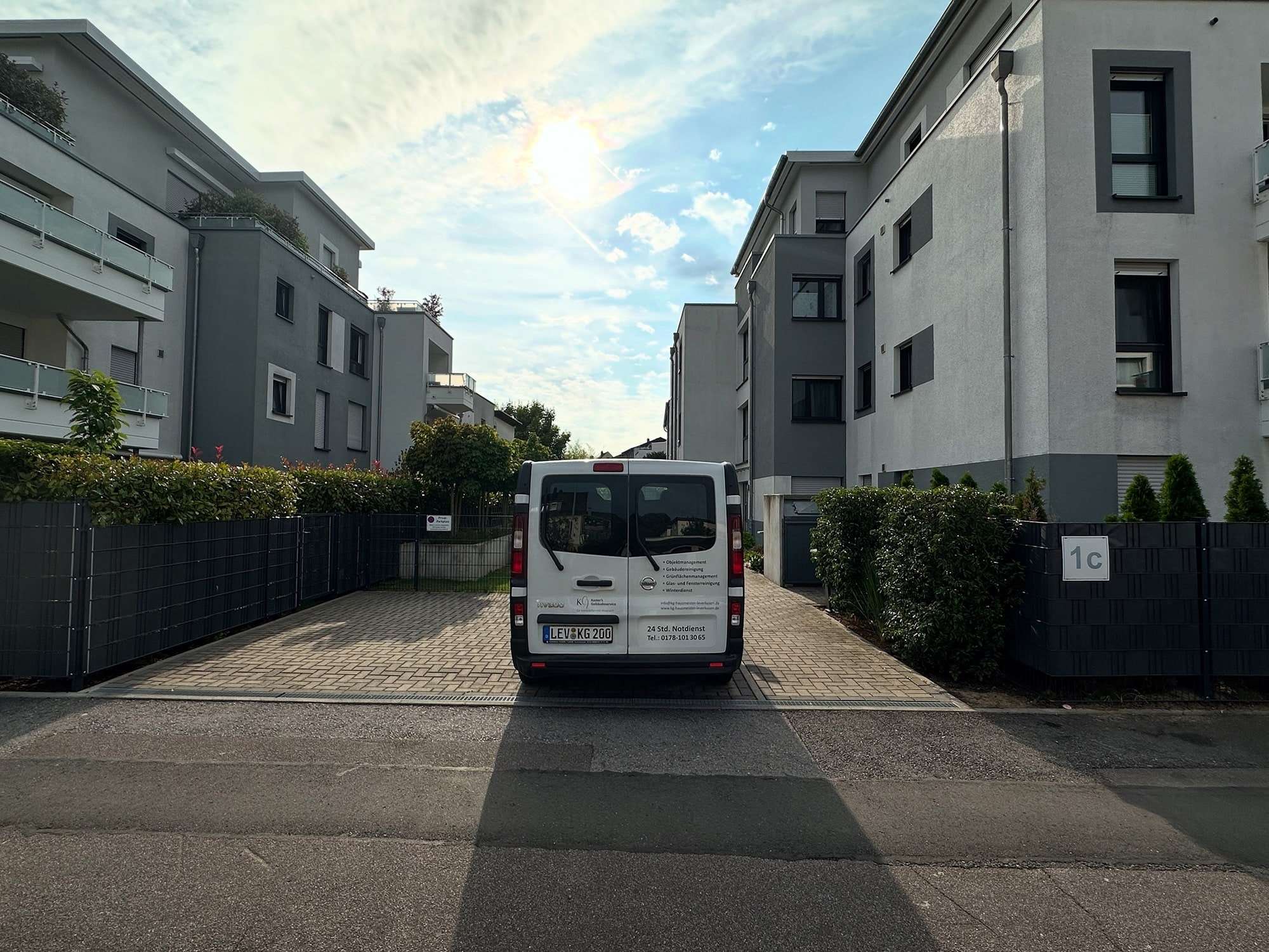 Fahrzeug von Kaster’s Gebäudeservice in der Zufahrt einer Wohnanlage